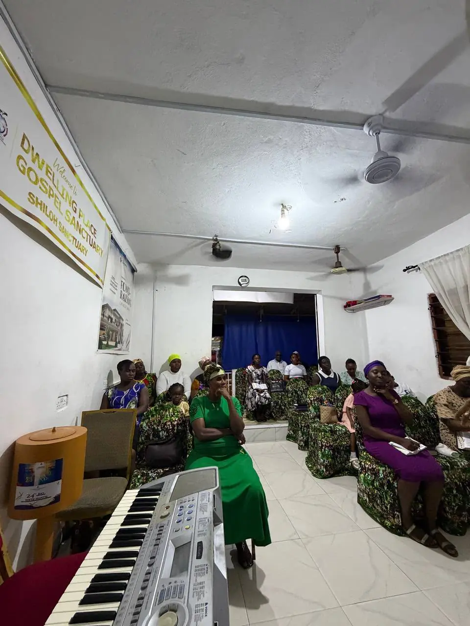 The sanctuary, with the Dwelling Place Gospel Sanctuary welcome banner beside the keyboard